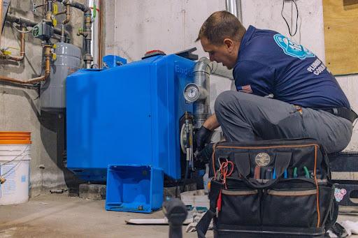 128 technician works on a heating system for a customer debating between oil vs gas vs electric heat 